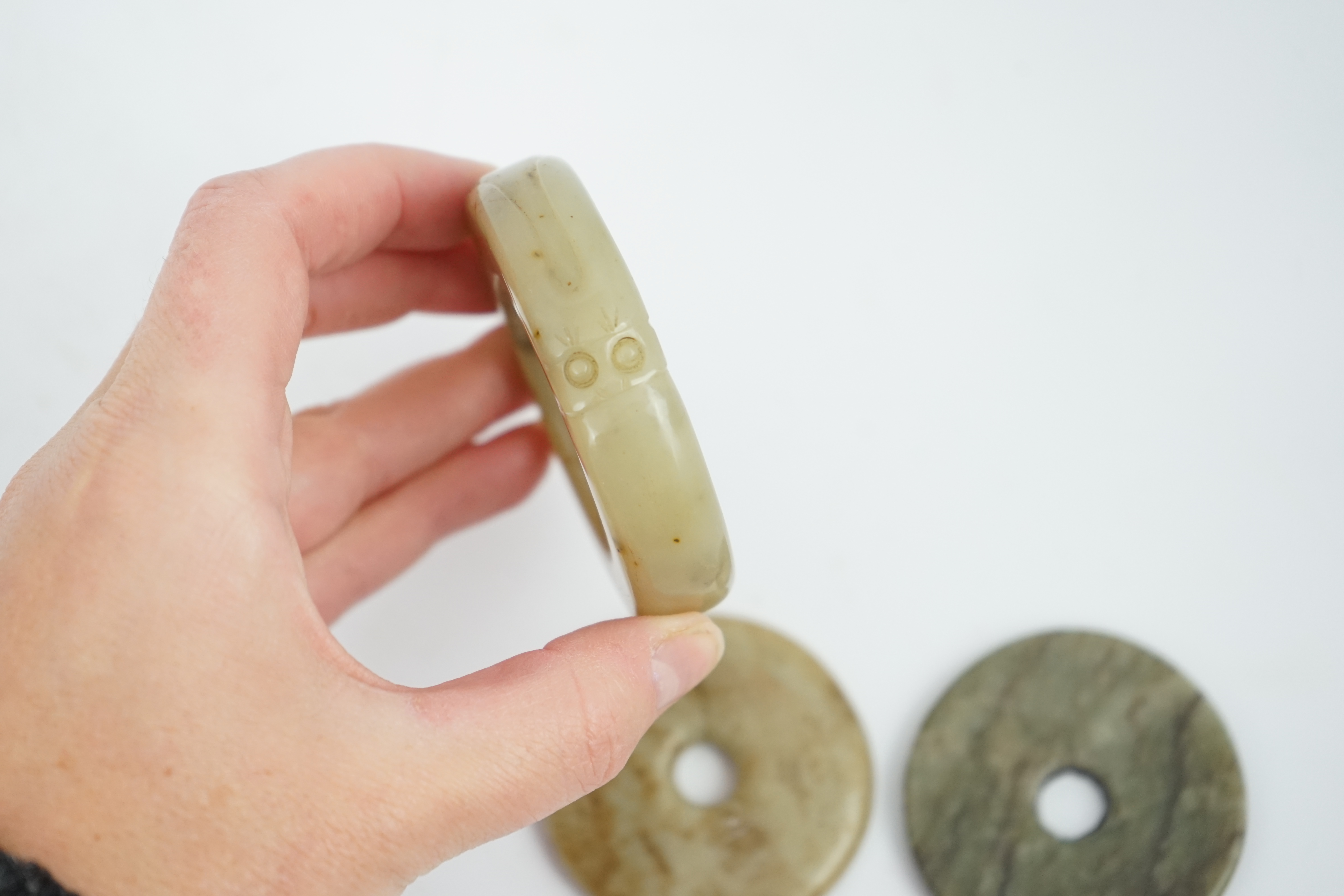 Two Chinese soapstone bi discs, and a jade ring, 18th century or earlier, largest 6.5cm in diameter. Condition - good